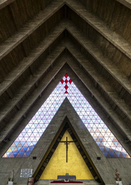 View of the altar and crucifix beneath stained-glass triangles inside the Cathedral of Our Lady of Fatima, Benguela Province, Benguela, Angola