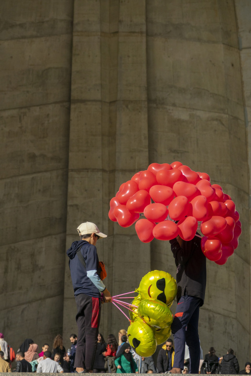 Balloon vendors selling red heart-shaped and yellow smiley-face balloons at the Martyrs' Memorial monument, North Africa, Algiers, Algeria