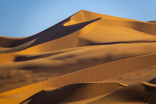 Dramatic light and shadow on sand dune ridges in the Sahara desert, Tassili N'Ajjer National Park, Tadrart Rouge, Algeria