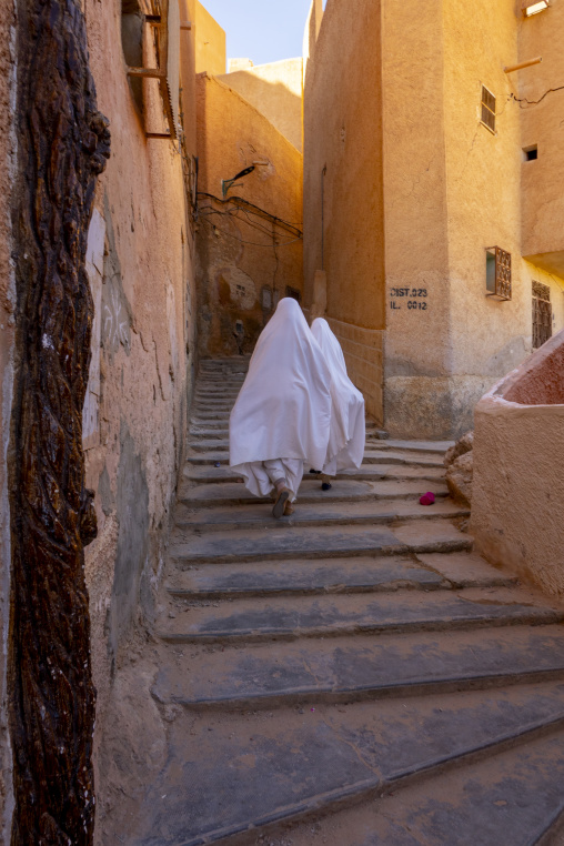 Mozabite women in white haïk in the streets of Ksar El Atteuf, North Africa, Ghardaia, Algeria