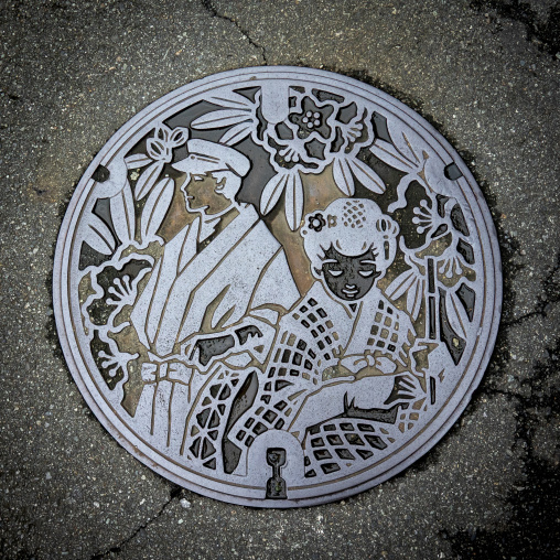 Decorative manhole cover with a traditional couple in Shizuoka p