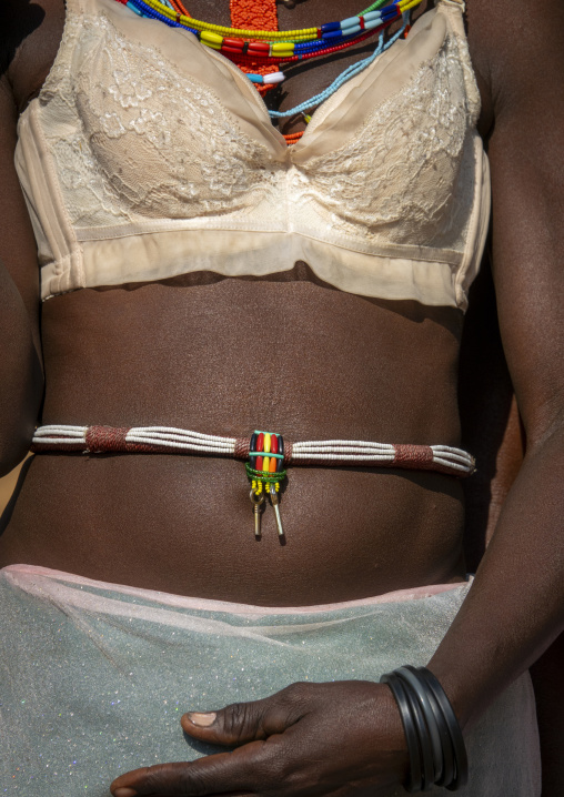 Close-up of a woman's torso wearing a lace bra beneath colorful beaded necklaces with key pendants, Cunene Province, Cahama, Angola