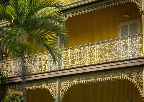 Multiple tiers of ornate ironwork balconies at the Palacio de Ferro seen through palm fronds, Luanda Province, Luanda, Angola