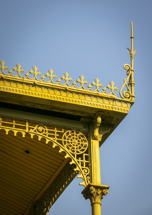 An arched iron bracket with a wheel-shaped rosette frames a corinthian column capital seen from below at the Palacio de Ferro, Luanda Province, Luanda, Angola