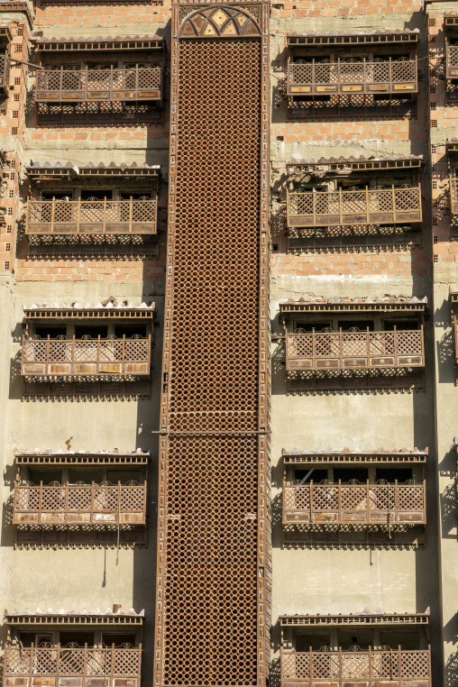 Rows of weathered wooden balconies on a historic building, Mecca