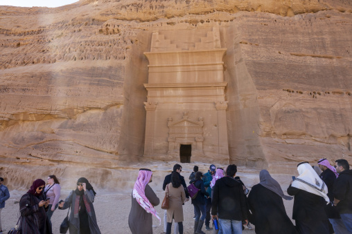 Tourists visiting a Nabataean tomb facade at Hegra, Al Madinah P