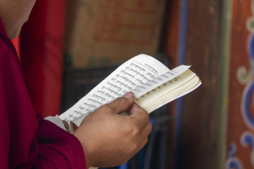 A monk reads a Tibetan scripture book at Shachong monastery, Qinghai Province, Wayaotai, China