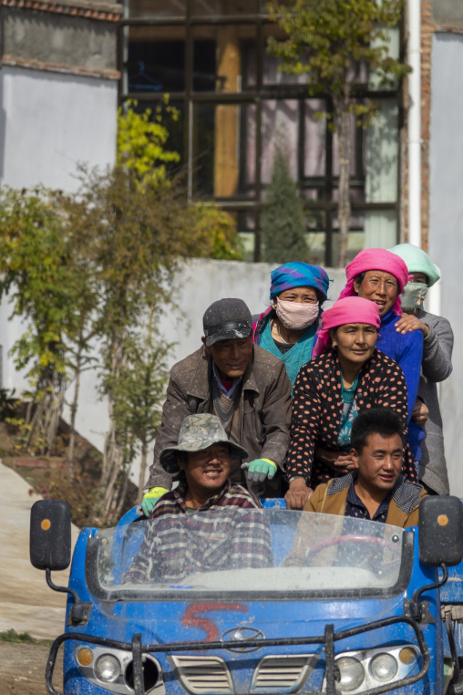 A group of Tibetan villagers rides together on a tractor near Shachong monastery, Qinghai Province, Wayaotai, China
