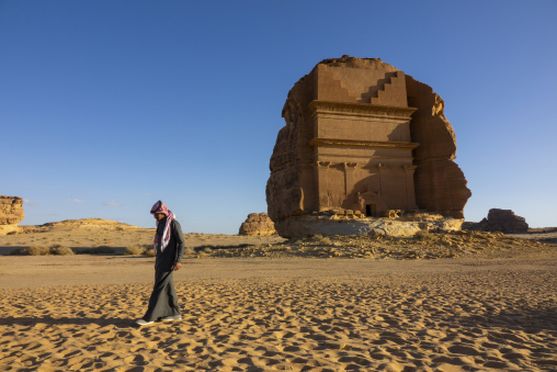 Man walking near Qasr al-Farid tomb carved from a single rock at