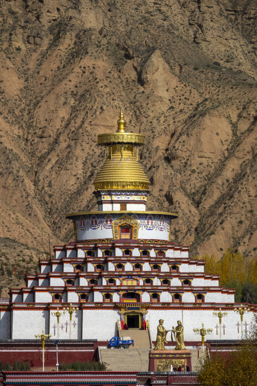 A large golden-topped stupa rises against a mountain backdrop, Tongren County, Rebkong, China
