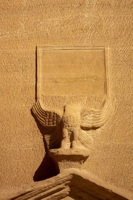 Weathered blank inscription panel above an eagle sculpture at He