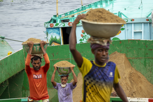 Laborers carrying bowls of sand on their heads from a painted ca