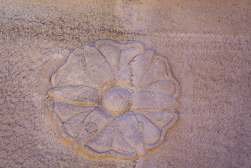 Weathered rosette carving on a Nabataean tomb facade at Hegra, A