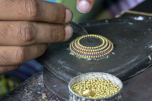 Metal worker using old lost wax casting method to create jewels, Dhaka Division, Dhamrai, Bangladesh