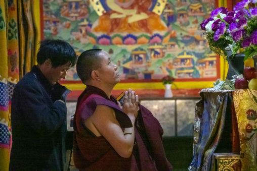 Monk praying and meditating inside Longwu monastery, Tongren County, Longwu, China