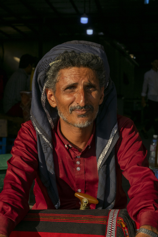 Portrait of a man selling traditional woven fabric at the market