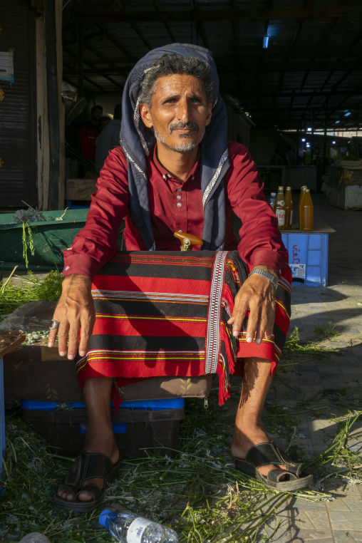 Portrait of a man selling traditional woven fabric at the market