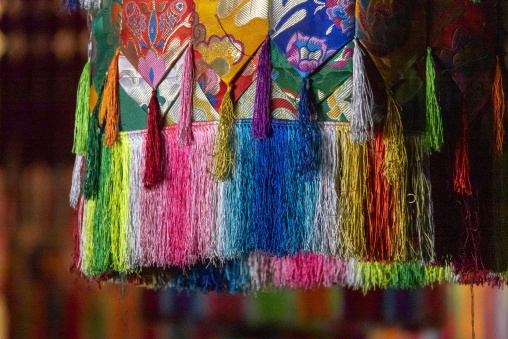 Colorful silk tassels decorating a pillar inside Longwu monastery, Tongren County, Longwu, China