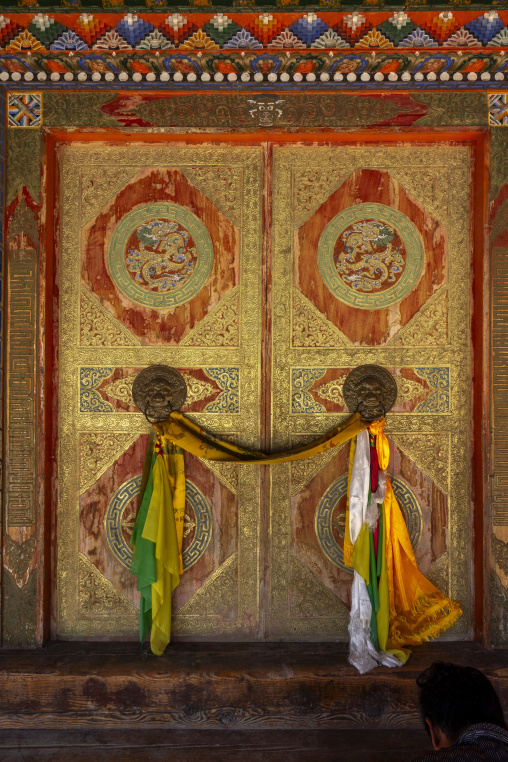 Ceremonial monastery door decorated with dragon motifs and silk scarves, Tongren County, Longwu, China