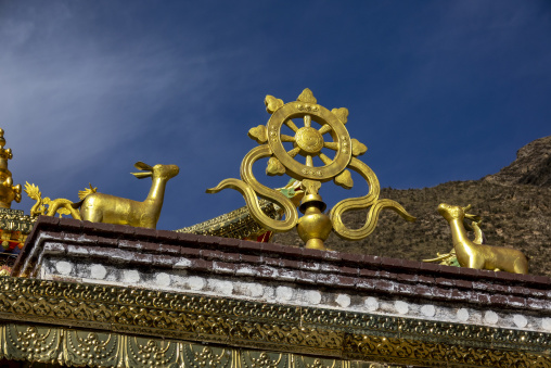 Golden Dharma wheel and deer statues on a monastery rooftop, Tongren County, Longwu, China