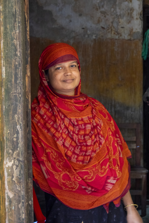 Portrait of a smiling woman in a doorway, Pabna District, Rooppu
