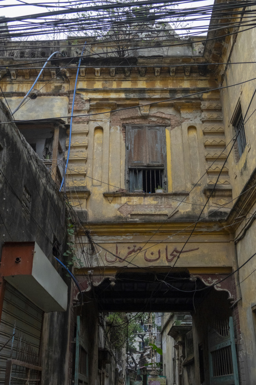 Weathered colonial-era building facade with a wooden shuttered w