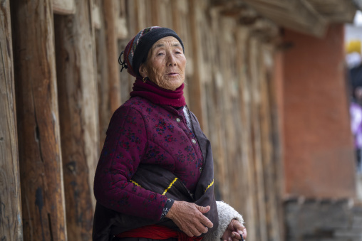 Elderly Tibetan woman stands at Labrang monastery, Gansu Province, Labrang, China