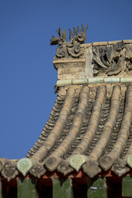 Curved roof tiles meet a dragon ornament at Dong Gong Guan mansion, Gansu Province, Linxia, China