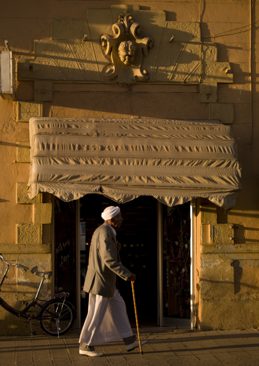 Eritrean man passing in front of an old italian house, Central Region, Asmara, Eritrea