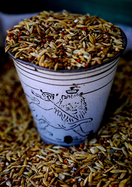 Seeds for sale in mercato in an old enamel cup with ethiopian lion, Central Region, Asmara, Eritrea