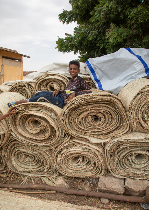 Eritrean boy sit on a stack of straw mats, Semien-Keih-Bahri, Keren, Eritrea