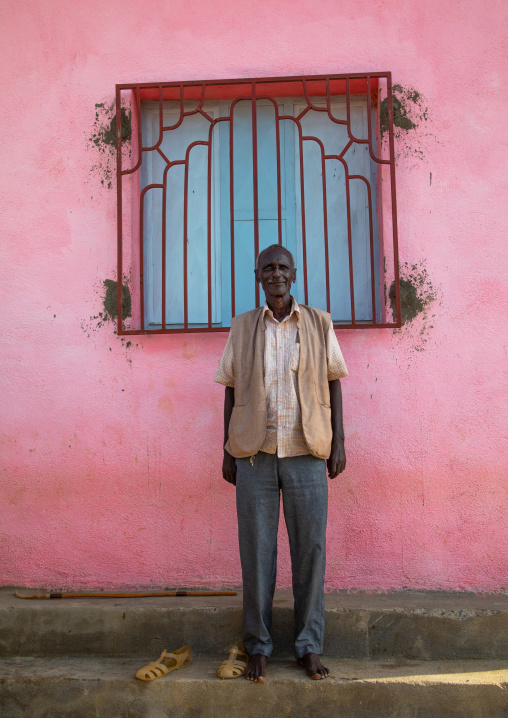 Eritrean man standing in front of a pink wall, Gash-Barka, Agordat, Eritrea
