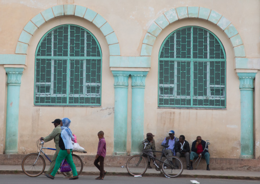 Eritrean people in front of a building from the italian colonial times near the mosque, Central region, Asmara, Eritrea