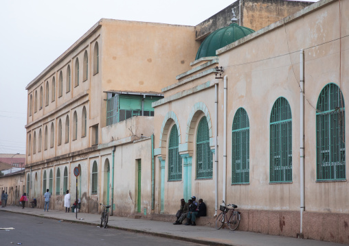 Eritrean people in front of a building from the italian colonial times near the mosque, Central region, Asmara, Eritrea