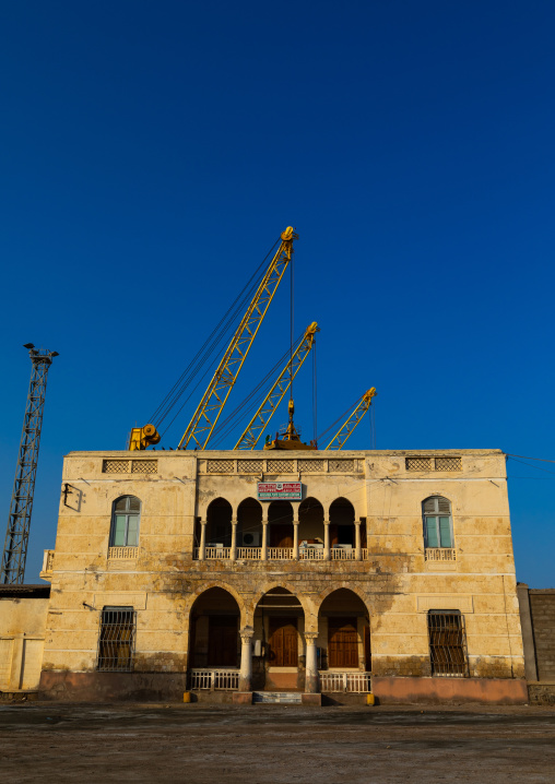 Ottoman architecture building with cranes in the back, Northern Red Sea, Massawa, Eritrea