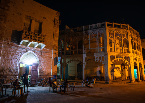 Eritrean men in an open air restaurant in front of ottoman architecture buildings, Northern Red Sea, Massawa, Eritrea