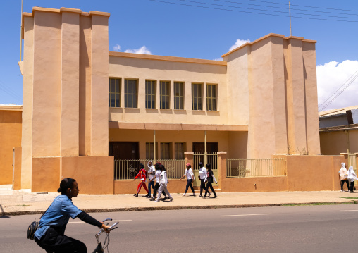 Teenagers passing in front an old italian colonial building, Central region, Asmara, Eritrea