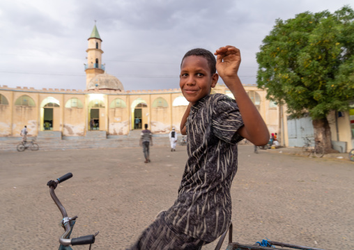 Eritrean boy riding a bicycle in front the grand mosque, Semien-Keih-Bahri, Keren, Eritrea