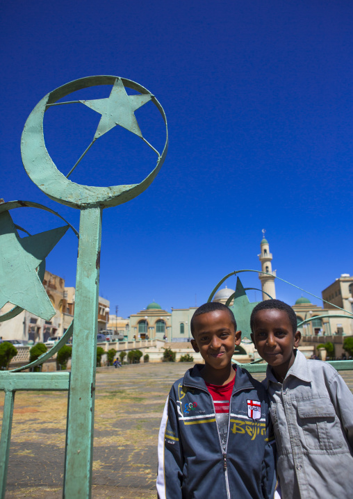 Eritrean boys standing in front of grand mosque kulafa al rashidin, Central Region, Asmara, Eritrea