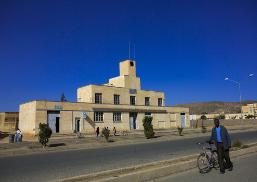 Eritrean man passing in front of an old colonial italian factory, Debub, Dekemhare, Eritrea