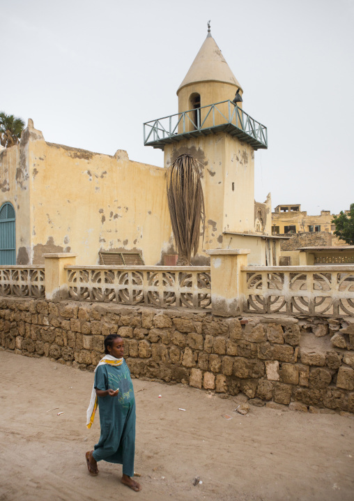 Eritrean woman passing in front of Hamal An Sari mosque, Northern Red Sea, Massawa, Eritrea