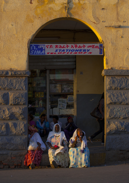Eritrean people sit under arcades in the city center, Central Region, Asmara, Eritrea