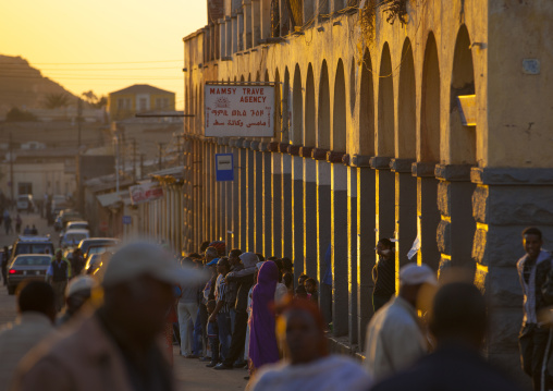 Eritrean people waiting for a bus in front of the arcades, Central Region, Asmara, Eritrea