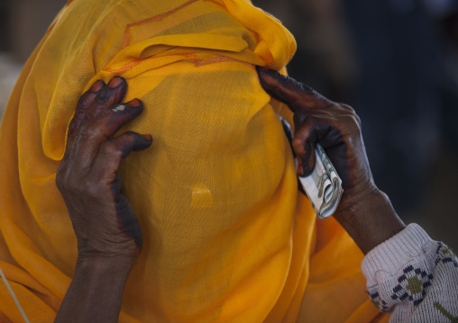 Eritrean woman hidding her face with a yellow scarf, Debub, Adi Keyh, Eritrea