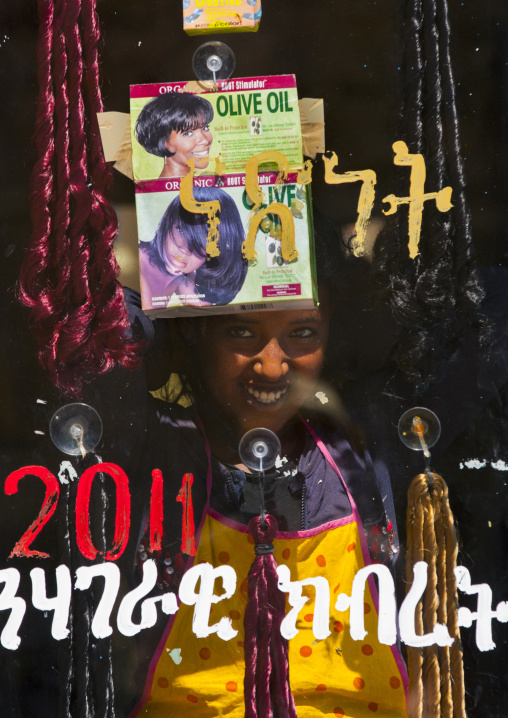 Eritrean woman standing behind the glass of a hairdresser, Debub, Adi Keyh, Eritrea