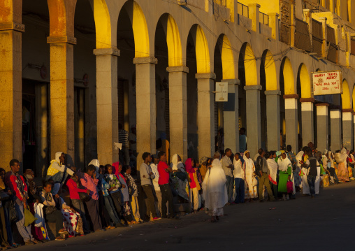 Eritrean people waiting for a bus in front of the arcades, Central Region, Asmara, Eritrea