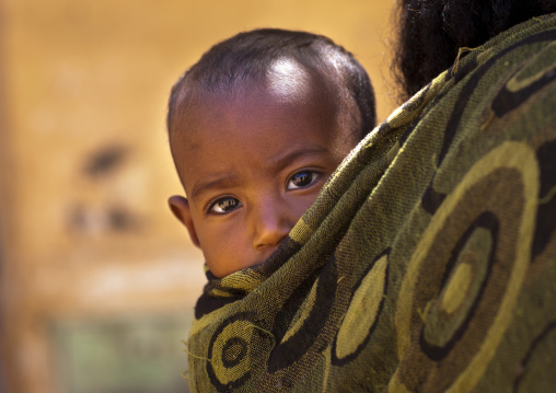 Portrait of an eritrean baby carried in the back of her mother, Debub, Mendefera, Eritrea