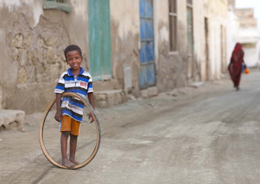 Eritrean boy playing with a bicycle tyre, Northern Red Sea, Massawa, Eritrea