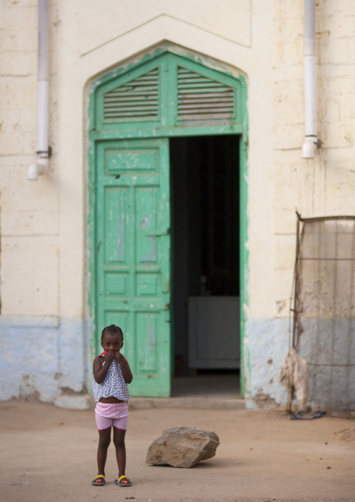 Eritrean girl standing in front of a green door, Northern Red Sea, Massawa, Eritrea