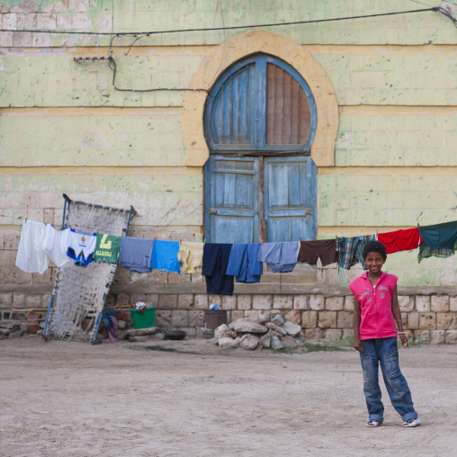 Eritrean boy pausing in front of an old ottoman house, Northern Red Sea, Massawa, Eritrea
